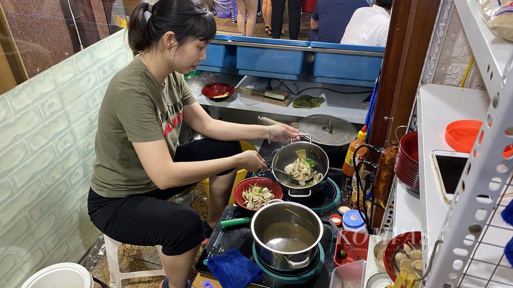 Hang Nga memasak ngao atau kerang Vietnam di kedai milikinya di kawasan Old Quarter, Hanoi, Vietnam, Sabtu (14/5/2022). Selain kerang, warga juga biasa menjajakan siput atau bekicot yang dikenal dengan nama oc van. Warga harus mencungkil kerang lalu mencelupkannya ke kuah bumbu untuk memakannya.
