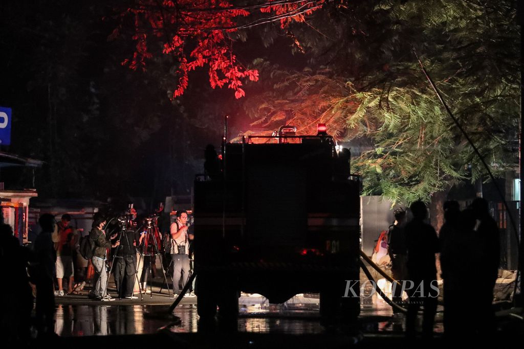 Wartawan berdiri di depan mobil pemadam di sekitar Museum Nasional, Jakarta, Sabtu (16/9/2023). Kebakaran yang melanda Museum Nasional pada Sabtu malam mengakibatkan bangunan di belakang gedung roboh. 