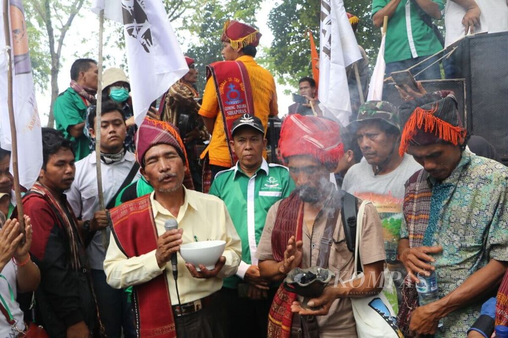 Masyarakat adat dari Desa Sihaporas, Kecamatan Pematang Sidamanik, Kabupaten Simalungun, melakukan ritual membakar kemenyan dalam unjuk rasa di Kantor DPRD Sumatera Utara, Medan, Senin (23/9/2019). Mereka meminta agar hak atas tanah ulayat mereka dikembalikan.