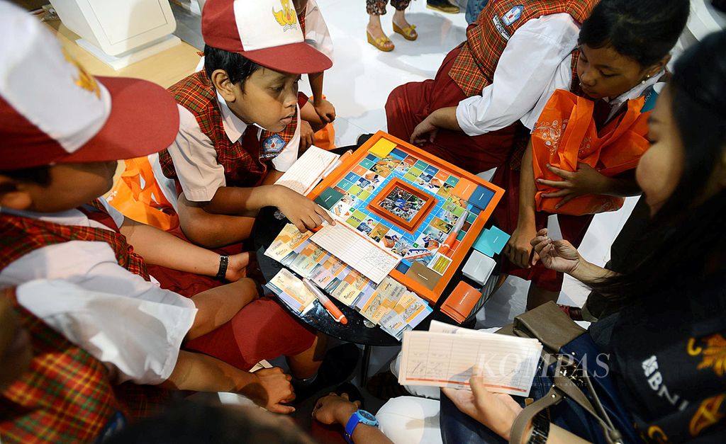 Anak-anak sekolah belajar mengelola uang dengan bermain monopoli di pameran Pasar Keuangan Rakyat yang diprakarsai Otoritas Jasa Keuangan di JIExpo, Jakarta, Minggu (21/12/2014). Pameran digelar untuk membantu masyarakat memiliki kemampuan dalam merencanakan keuangan. 