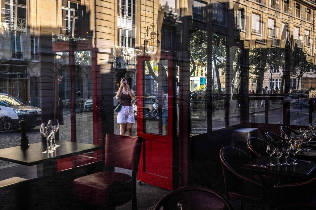 Seorang perempuan memotret restoran Terra Nera, salah satu lokasi ikonik yang muncul pada serial Netflix, <i>Emily in Paris,</i> di Paris, Perancis, 27 Agustus 2024. 