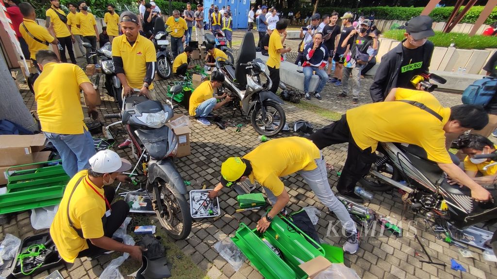 Sejumlah teknisi mengonversi sepeda motor mesin berbahan bakar minyak ke sepeda motor listrik pada Electric Vehicle Funday di Plaza Timur, Gelora Bung Karno, Jakarta, Minggu (18/12/2022). 