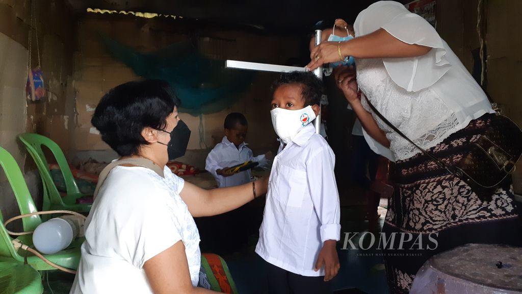 Petugas puskesmas dan kader posyandu Desa Kesetnana, Kecamatan Mollo Selatan, Kabupaten Timor Tengah Selatan, Provinsi Nusa Tenggara Timur, mengukur tinggi badan Sandi Santiago Numlene (5) yang tengkes.