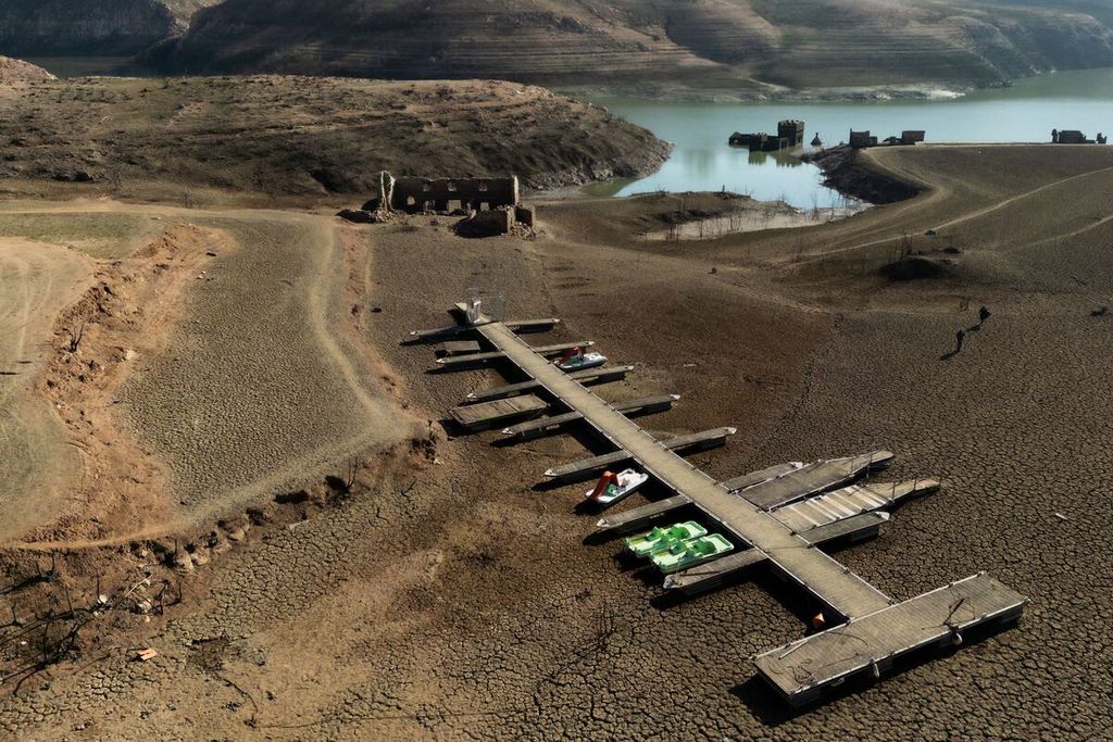 Dermaga dan perahu di tanah kering di tepi Waduk Sau dengan permukaan air rendah di Provinsi Girona di Catalonia, Spanyol, Jumat (2/2/2024). Sau merupakan salah satu waduk utama yang menyediakan air ke wilayah metropolitan Barcelona. Ketinggian airnya di bawah 4,06 persen setelah tiga tahun kekeringan di Catalonia. Wilayah timur laut Spanyol mengumumkan darurat kekeringan pada 1 Februari untuk Barcelona dan wilayah sekitarnya yang akan menghadapi pembatasan air yang lebih ketat.
