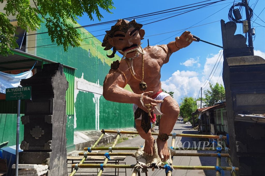 Sebuah ogoh-ogoh ditempatkan di depan gerbang salah satu lingkungan di Kelurahan Cilinaya, Kecamatan Cakranegara, Kota Mataram, Nusa Tenggara Barat, saat umat Hindu menjalani catur bratha penyepian dalam rangka hari raya Nyepi Tahun Baru Saka 1945, Rabu (22/3/2023). Berbeda dengan tahun sebelumnya yang dilarang karena Covid-19, tahun ini umat Hindu di Lombok bisa melaksanakan parade ogoh-ogoh.