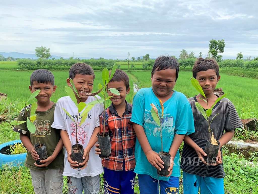 Anak-anak ikut mengambil bagian dalam gotong royong menanam pohon di pinggir jalan Desa Wisata Hijau Bilebante, Lombok Tengah, Nusa Tenggara Barat, Jumat (12/2/2021) pagi. Kegiatan yang merupakan bagian dari program Kuliah Kerja Nyata (KKN) Tematik Universitas Mataram itu, diharapkan menumbuhkan kepedulian terhadap lingkungan sejak dini, termasuk menjadikan salah satu desa penyangga Kawasan Ekonomi Khusus (KEK) Mandalika itu semakian hijau dan asri.