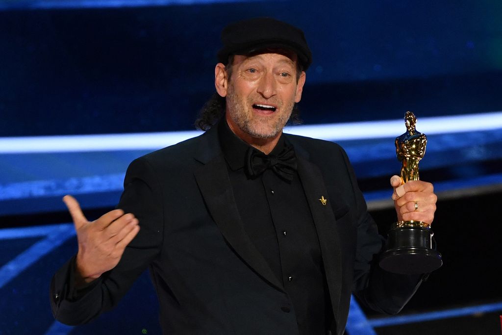 Aktor asal Amerika Serikat, Troy Kotsur, menerima penghargaan Piala Oscar untuk Aktor Terbaik dalam Peran Pendukung untuk film <i>CODA</i> (2021) di atas panggung dalam perhelatan Academy Awards ke-94 di Dolby Theatre, Hollywood, California, pada 27 Maret 2022. Kotsur mencatat sejarah sebagai aktor tunarungu pertama dan pemain film tunarungu kedua yang menang sepanjang sejarah Piala Oscar.