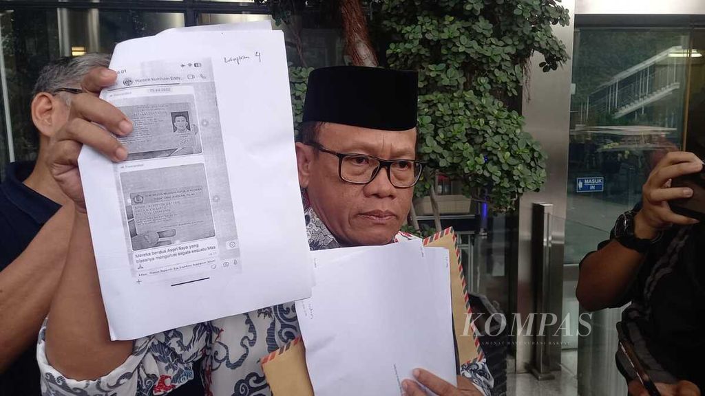 Ketua Indonesia Police Watch (IPW) Sugeng Teguh Santoso menunjukkan salah satu bukti laporannya terkait dugaan penerimaan gratifikasi oleh Wakil Menteri Hukum dan Hak Asasi Manusia Eddy OS Hiariej di gedung Merah Putih KPK, Jakarta, Selasa (14/3/2023). Eddy dilaporkan atas dugaan penerimaan gratifikasi sekitar Rp 7 miliar.