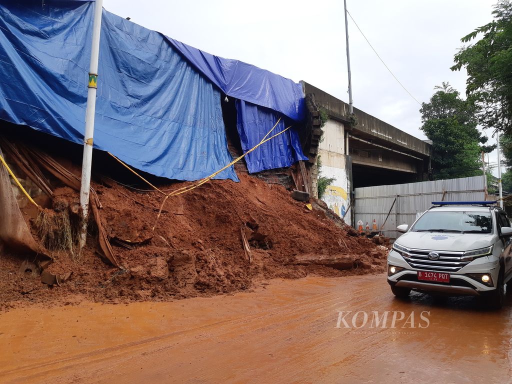 Material longsor dinding penahan jalan tol Jorr ruas Bintaro masih tertumpuk di pinggiran jalan, Minggu (7/7/2024). Longsor di area jalan ini kerap terjadi, terutama ketika hujan mengguyur.