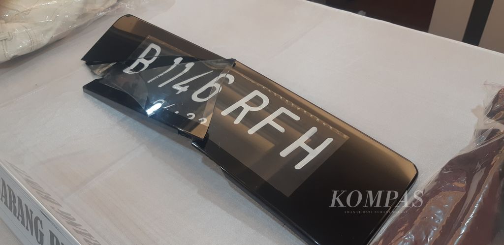Pelat mobil yang rusak dalam insiden kecelakaan kecil di jalan tol di Jakarta Selatan yang berujung pada kasus pemukulan. Polda Metro Jaya merilis kasus ini dalam konferensi pers di Polda Metro Jaya, Jakarta, Senin (6/6/2022).