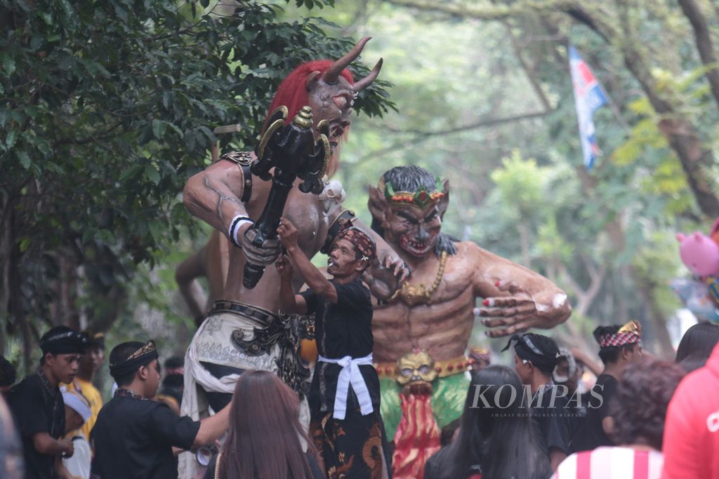 Peserta sedang memperbaiki ogoh-ogoh sebelum acara dimulai.