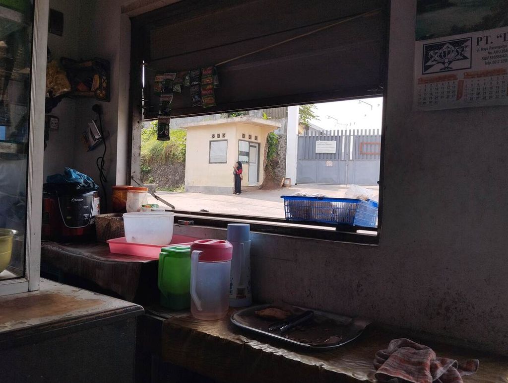 Seorang perempuan tengah berdiri di depan gerbang Pabrik Rokok Zabur Rizqie, di Jalan Parangargo, Kecamatan Wagir, Kabupaten Malang, Jawa Timur, Senin (29/7/2024). Pabrik ini merupakan tempat rokok Saga Bold diproduksi.