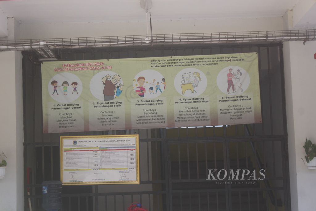Sebuah spanduk antiperundungan terbentang di teralis besi yang ada di SD Negeri 06 Petukangan Utara, Kecamatan Pesanggrahan, Jakarta Selatan, Kamis (28/9/2023).