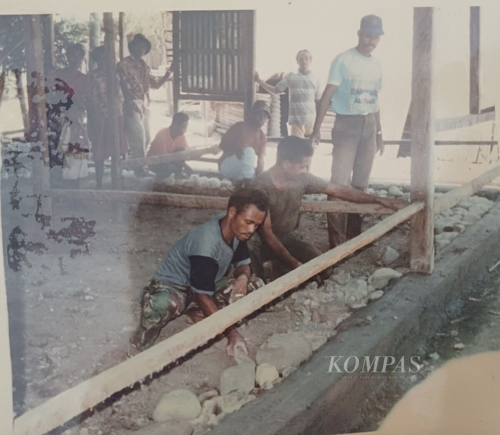 Anggota TNI bersama masyarakat lokal Lospalos, Timor Timur, membangun rumah warga, Juli 1998.