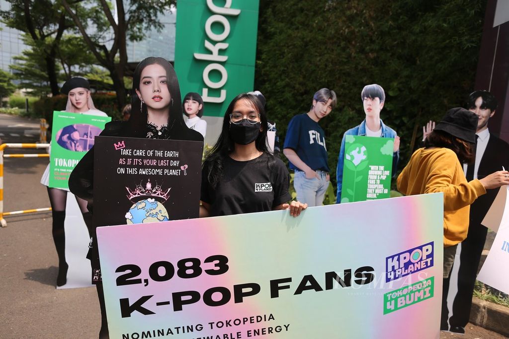 Fans K-Pop yang tergabung dalam Kpop4Planet melakukan aksi damai di depan Tokopedia Tower, Jakarta, Oktober 2021. Fans K-Pop menominasikan Tokopedia, yang menunjuk BTS dan Blackpink sebagai <i>brand ambassador</i>, untuk segera berkomitmen menggunakan energi terbarukan 100 persen pada tahun 2030.