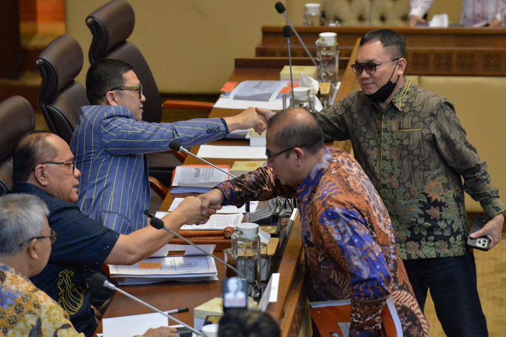 Wakil Ketua Komisi II DPR Junimart Girsang (kiri dari bawah) bersalaman dengan Ketua KPU Hasyim Asy’ari (kanan dari bawah) di gedung Komisi II DPR, Senin (6/1/2023). 