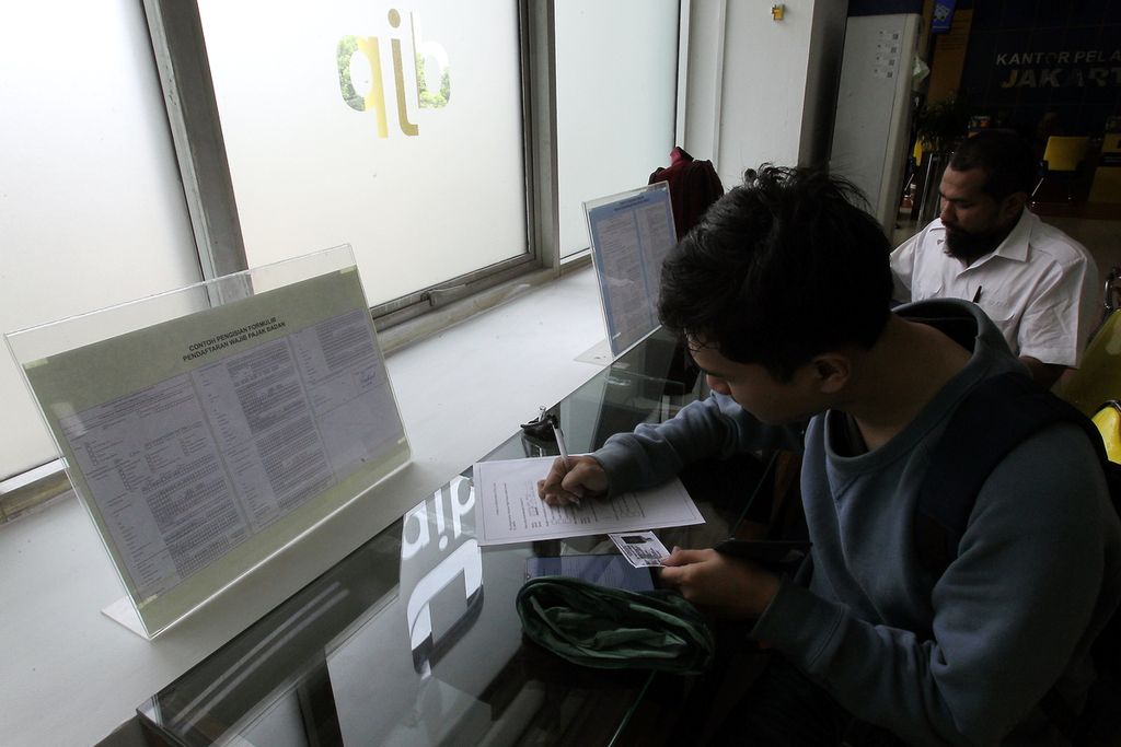 Wajib pajak mengisi formulir sebelum dilayani petugas pajak dari Kantor Pelayanan Pajak Pratama Jakarta Cilandak, Jakarta, Jumat (20/12/2019). 