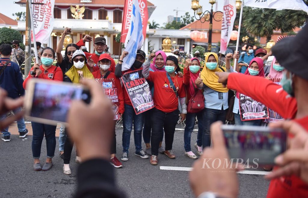 Buruh berunjuk rasa di depan Gedung Grahadi, Kota Surabaya, Jawa Timur, Rabu (1/3/2022). Buruh yang tergabung di Gerakan Serikat Pekerja Jawa Timur (GASPER) menolak Permenaker Nomor 2 Tahun 2022 tentang Tata Cara dan Persyaratan Pembayaran Manfaat Jaminan Hari Tua. Buruh terdiri dari serikat buruh dari Pasuruan, Gresik, Sidoarjo, dan Surabaya. Kemacetan lalu lintas tidak bisa dihindari akibat massa menutup sejumlah jalan utama menuju Gedung Grahadi. 