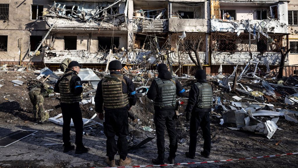 Tentara Ukraina berdiri di dekat puing-puing gedung apartemen yang hancur di Kiev, Ukraina (15/3/2022). Serangkaian ledakan dahsyat mengguncang distrik perumahan di Kiev beberapa jam sebelum perundingan antara Ukraina dan Rusia. 