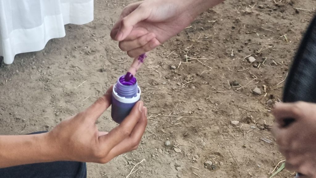 Salah satu warga yang selesai menggunakan hak pilihnya di salah satu TPS Kecamatan Antapani, Kota Bandung, Jawa Barat, mencelupkan jarinya di tinta, Rabu (14/2/2024).