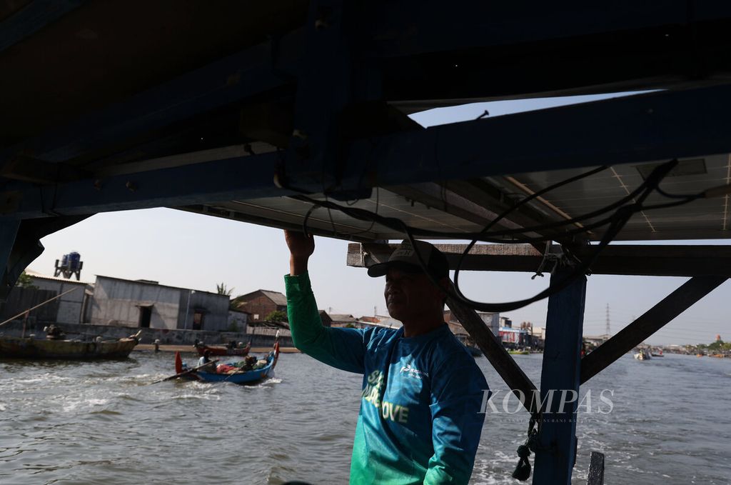 Salah satu nelayan menggunakan perahunya saat meninggalkan dermaga untuk menuju muara pantai Kampung Tambakrejo, Kota Semarang, Jawa Tengah, Senin (28/7/2025). 