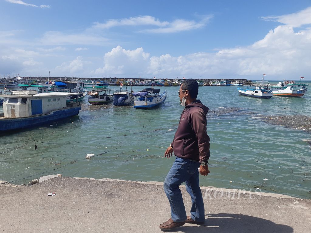 Warga melintas di Tempat Pendaratan Ikan Oeba di Kota Kupang, Nusa Tenggara Timur, Sabtu (7/1/2023). Tempat tersebut merupakan tempat pendaratan ikan terbesar di Kupang.  