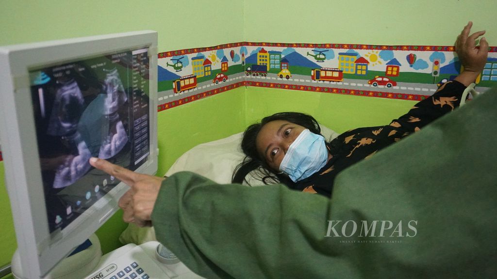 Nining Pujiastuti (41) menatap layar hasil pemeriksaan ultrasonografi (USG) yang dilakukan di Puskesmas Sedayu 1, Bantul, DI Yogyakarta, Jumat (10/2/2023). Pemeriksaan USG amat penting bagi ibu hamil untuk mendeteksi dini adanya gangguan pada kehamilan yang dapat menyebabkan kematian ibu dan bayi. 