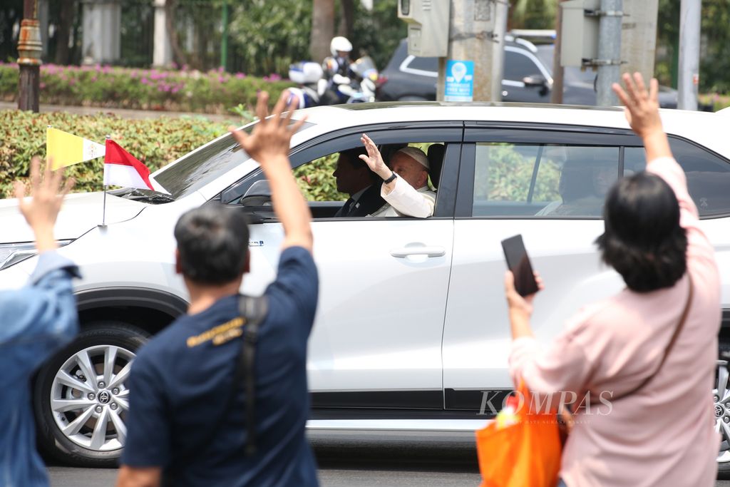 Paus Fransiskus menyapa umat yang telah menunggunya di tepi Jalan Merdeka Selatan, Jakarta, seusai ia bertemu dengan Presiden Joko Widodo di Istana Negara  (4/9/2024). 