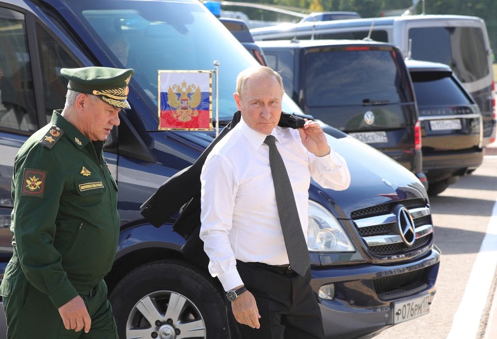 Presiden Rusia Vladimir Putin (kanan) dan Menteri Pertahanan Rusia Sergei Shoigu tiba dalam acara pembukaan International Army Games 2022 di Kubinka, Rusia, Senin (15/8/2022). Shoigu membuat kontrak baru bagi pasukan militer swasta yang memicu kemarahan kelompok Wagner.