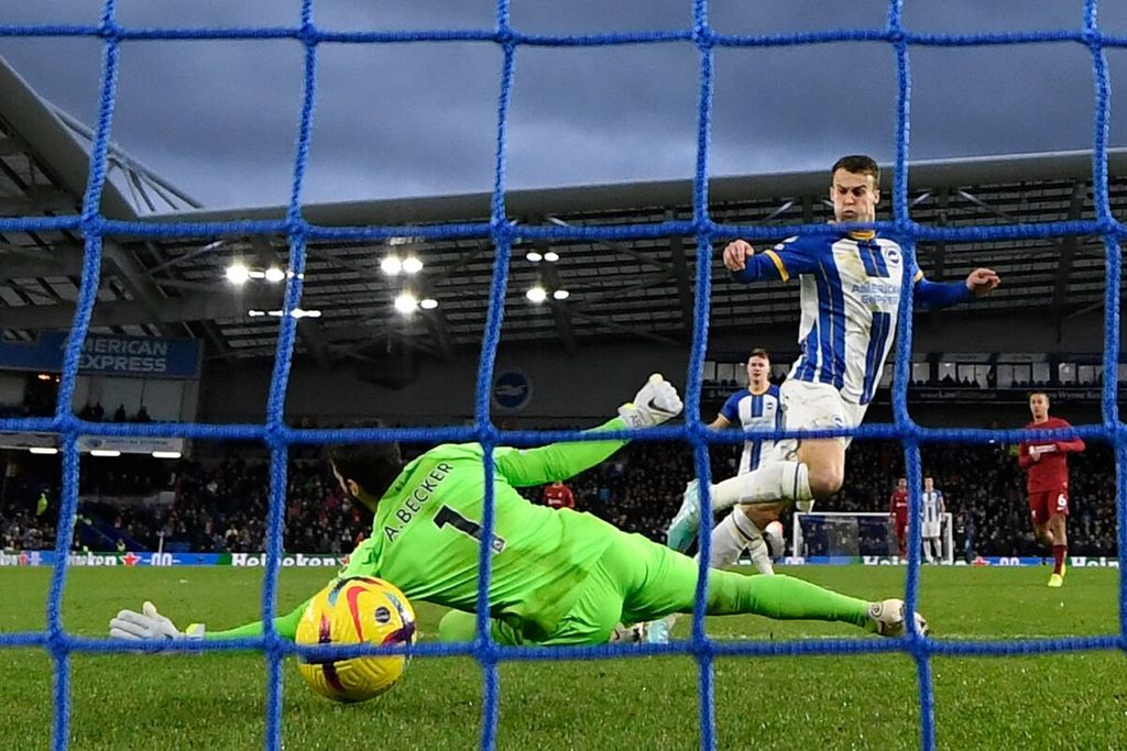 Pemain Brighton, Solly March (kanan), mencetak gol ke gawang Liverpool yang dijaga kiper Alisson Becker pada laga Liga Inggris di Stadion American Express Community, Brighton, Inggris, Minggu (15/1/2023) dini hari WIB. Brighton menang 3-0 pada laga itu.