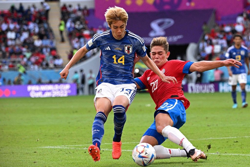 Gelandang Jepang, Junya Ito (kiri), berebut bola dengan gelandang Kosta Rika, Brandon Aguileras, dalam pertandingan Grup E Piala Dunia Qatar antara Jepang dan Kosta Rika di Stadion Ahmad Bin Ali, Al Rayyan, Minggu (27/11/2022).