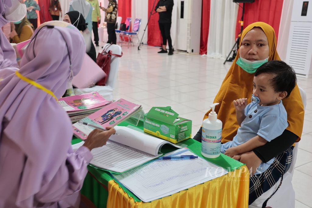 Seorang ibu membawa anak balitanya ke Kelurahan Kayubulan, Kabupaten Gorontalo, Provinsi Gorontalo, Jumat (14/4/2023). Pengukuran berat dan tinggi badan anak balita secara berkala dapat memantau perkembangan anak sekaligus mengantisipasi tengkes (<i>stunting</i>).