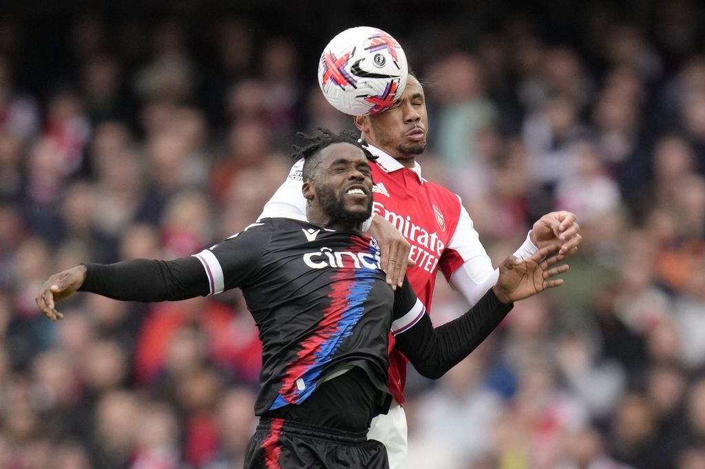 Pemain Crystal Palace Jeffrey Schlupp (kiri) berebut bola dengan pemain Arsenal Gabriel pada laga Liga Ingris di Stadion Emirates, London, Minggu (19/3/2023) WIB. Pada laga itu, Arsenal menang dengan skor 4-1 dan Schlupp mencetak satu gol untuk Palace. 