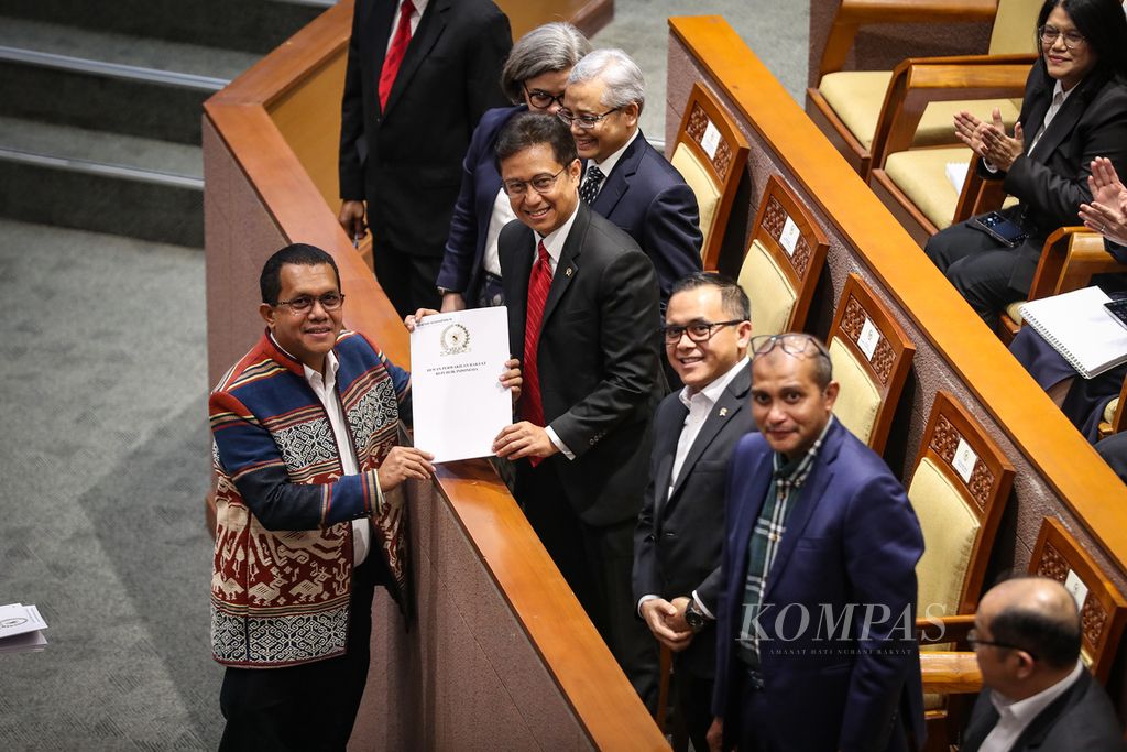 Wakil Ketua Komisi IX DPR dan Ketua Panja RUU Kesehatan Emanuel Melkiades Laka Lena (kiri) menyerahkan berkas terkait RUU Kesehatan kepada Menteri Kesehatan Budi Gunadi Sadikin (kanan) dalam rapat paripurna di Gedung Parlemen, Jakarta, Selasa (11/7/2023).