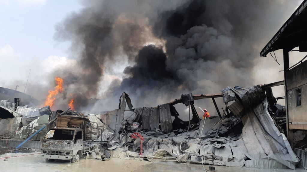 Petugas Badan Penanggulangan Bencana Daerah (BPBD) Kota Tangerang menyemprotkan air ke gudang cat milik PT Kansai Prakarsa Coatings di Jatiuwung, Kota Tangerang, Banten. Kebakaran terjadi pada Rabu (17/6/2020) pukul 01.00. Hingga siang hari api belum berhasil dipadamkan
