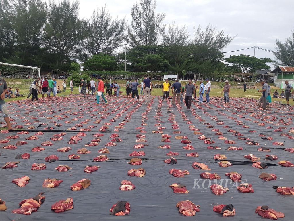 Suasana pembagian daging kurban di Desa Meunasah Papeun, Kecamatan Krueng Barona Jaya, Kabupaten Aceh Besar, Provinsi Aceh, Senin (11/7/2022). Ternak yang dipotong untuk kurban telah melalui pemeriksaan kesehatan agar terhindar dari PMK.