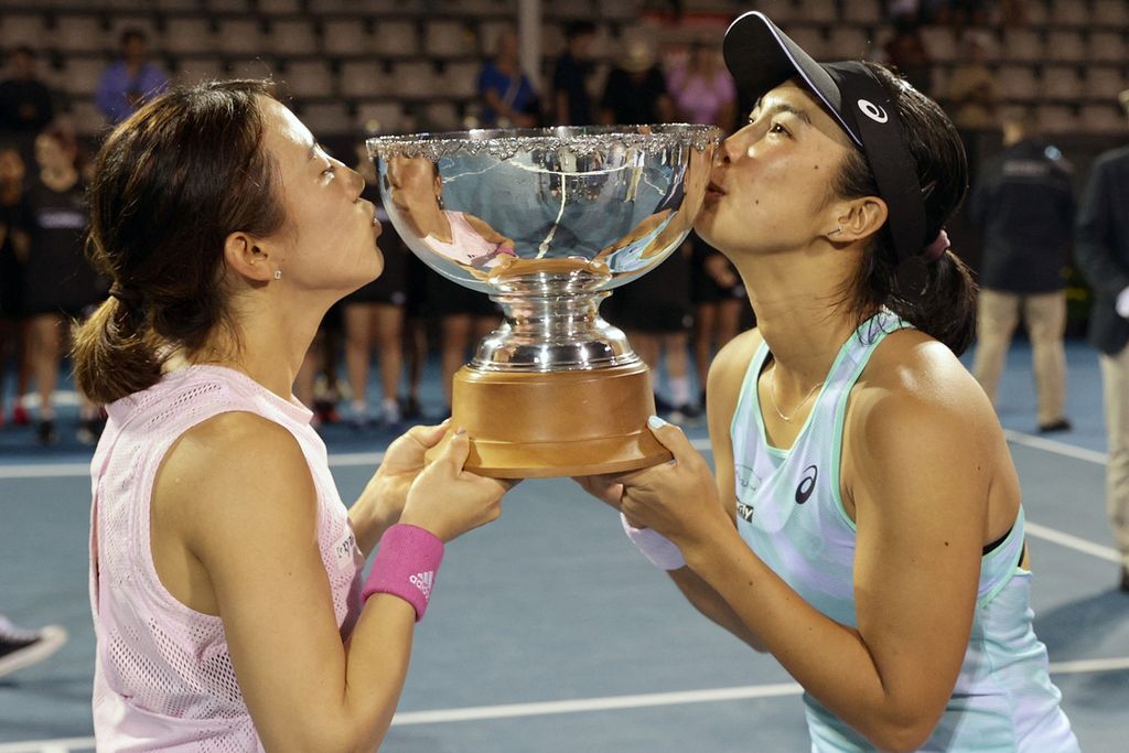 Petenis Indonesia Aldila Sutjiadi (kanan) dan petenis Jepang Miyu Kato mencium trofi setelah menjuarai nomor ganda putri turnamen WTA 250 Auckland, di Auckland, Selandia Baru, Senin (9/1/2023). Aldila/Kato mengalahkan Leylah Fernandez (Kanada) yang berpasangan dengan Bethanie Mattek-Sands (Amerika Serikat). 