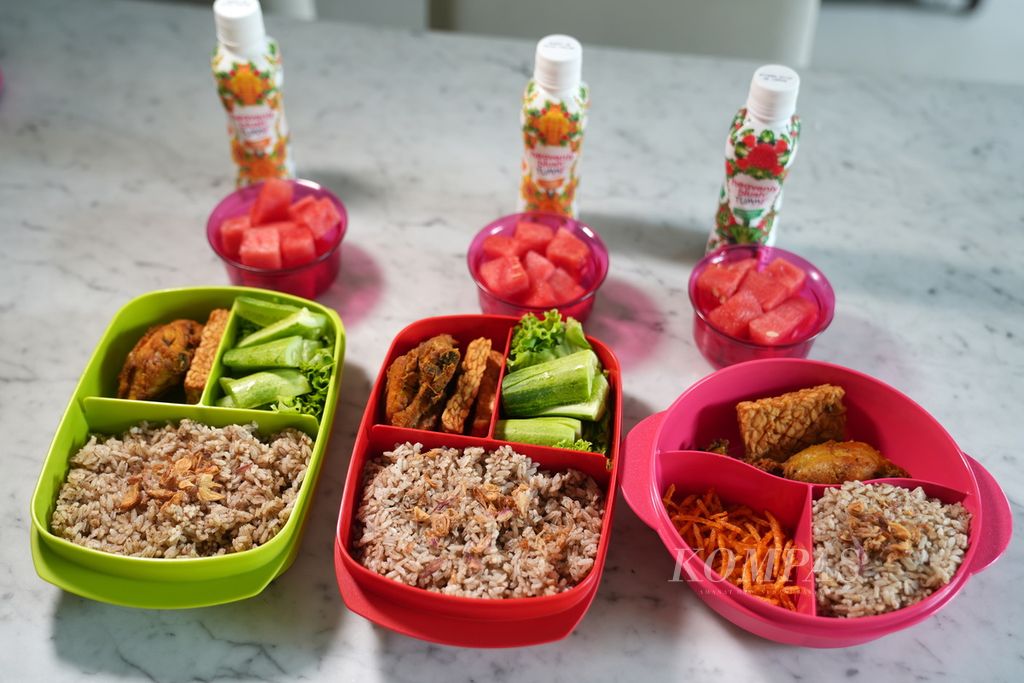Nasi kebuli dengan lauk potongan ayam dan tempe goreng untuk bekal makan siang di kantor disiapkan oleh karyawan. Selain terjamin kebersihannya, bekal makan juga menjadi strategi kaum menengah di tengah impitan ekonomi.