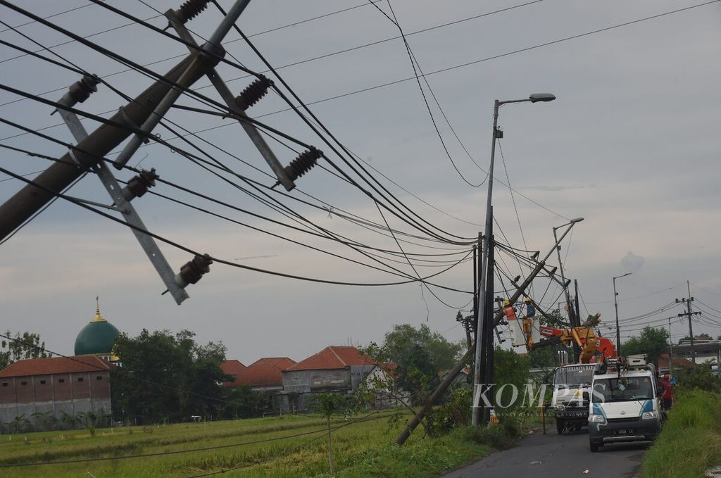 Tampak proses perbaikan tiang listrik 20 KV yang roboh diterjang angin kencang di Desa Sambungrejo, Kecamatan Sukodono, Sidoarjo, Jawa Timur, pada Senin (4/11/2024). Angin kencang menyebabkan tiga tiang listrik roboh di kawasan tersebut. Selain merusak tiang listrik, hujan disertai angin juga menyebabkan pohon roboh serta sejumlah bangunan rusak. Masyarakat diimbau untuk mengantisipasi bencana hidrometeorologi yang meningkat saat musim pancaroba.