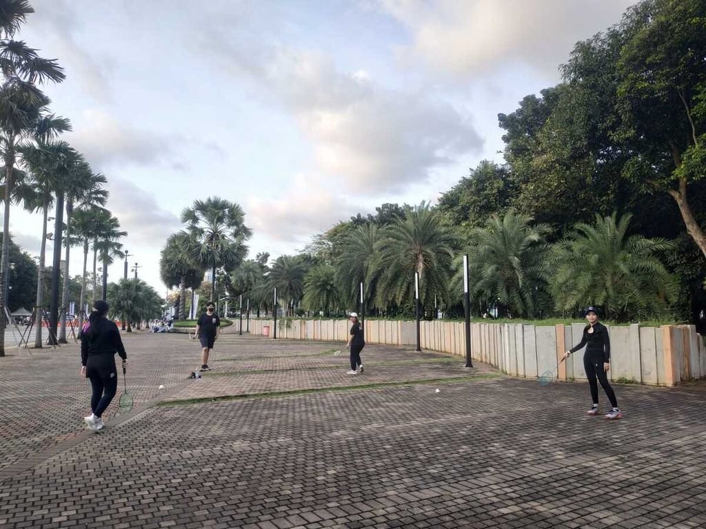 Pengunjung berolahraga bulu tangkis di kawasan Stadion Gelora Bung Karno, Jakarta Pusat, Minggu (18/3/2023).