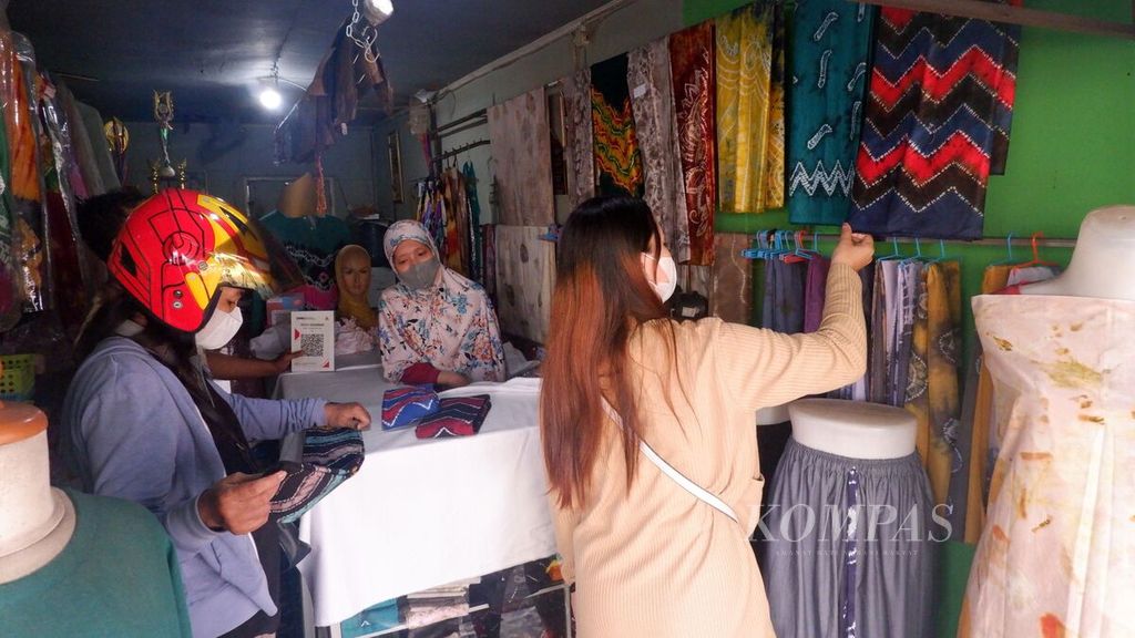 Calon pembeli melihat kain sasirangan di toko Katuju Sasirangan yang berada di Kampung Sasirangan, Jalan Seberang Mesjid, Kelurahan Seberang Mesjid, Kecamatan Banjarmasin Tengah, Kota Banjarmasin, Kalimantan Selatan, Rabu (21/9/2022). 