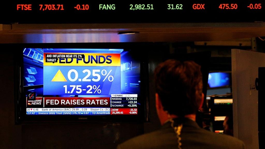 A trader stands in front of a monitor broadcasting the Fed Rate hike on June 13, 2018 at the New York Stock Exchange (NYSE) in New York City.