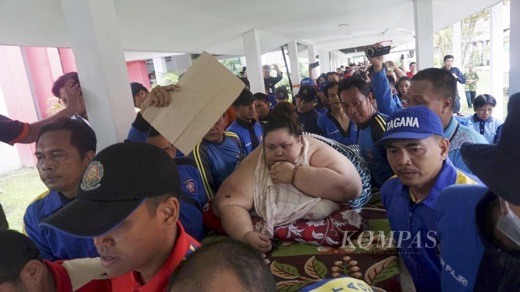 Titi Wati (37), wanita penderita obesitas dengan berat lebih dari 300 kilogram, digotong tim pemadam kebakaran Kota Palangkaraya, Kalimantan Tengah, menuju ruangannya di Rumah Sakit Umum Daerah (RSUD) Doris Sylvanus Palangkaraya, Jumat (11/1/2019). Titi akan menjalani operasi bariatrik.