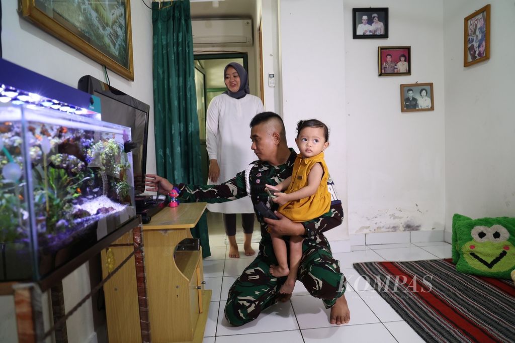 Kopral Dua Haris Aditya bercengkerama dengan keluarganya di rumah susun prajurit TNI AD di Cililitan, Jakarta Timur, Selasa (6/9/2022). Terdapat lima tower dalam kompleks rumah susun prajurit TNI AD ini. 