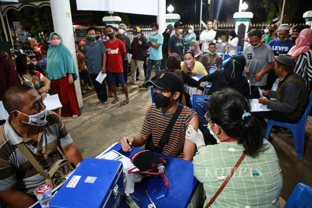 Warga menerima suntikan vaksin penguat (<i>booster</i>)<i> </i>di gerai vaksin presisi yang digelar di halaman Masjid Al-Ikhlas, Larangan Selatan, Larangan, Kota Tangerang, Banten, Sabtu (9/4/2022) malam. 