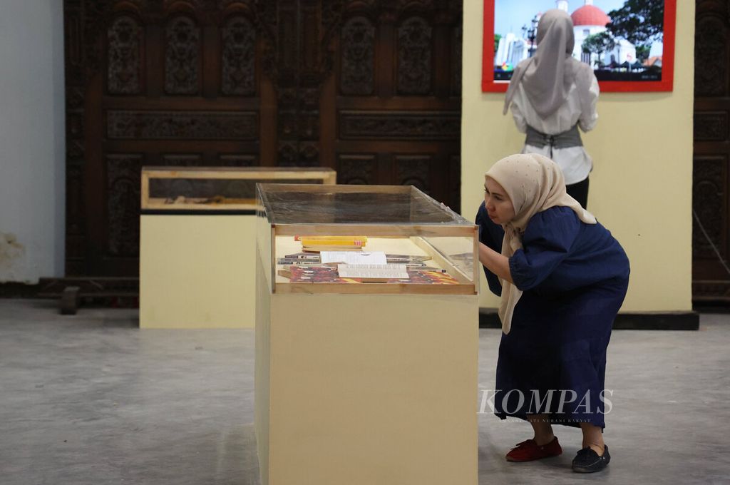 Pengunjung saat melihat rak kaca berisi koleksi buku sejarah sebagai bagian dari pameran Jalur Sutra Maritim di Gedung Oudetrap, Kota Lama, Kota Semarang, Jawa Tengah, Jumat (3/10/2025). 