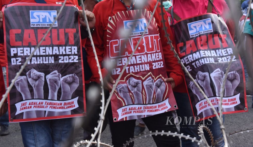 Buruh berunjuk rasa dengan membawa poster penolakan di depan Gedung Grahadi, Kota Surabaya, Jawa Timur, Rabu (1/3/2022). 