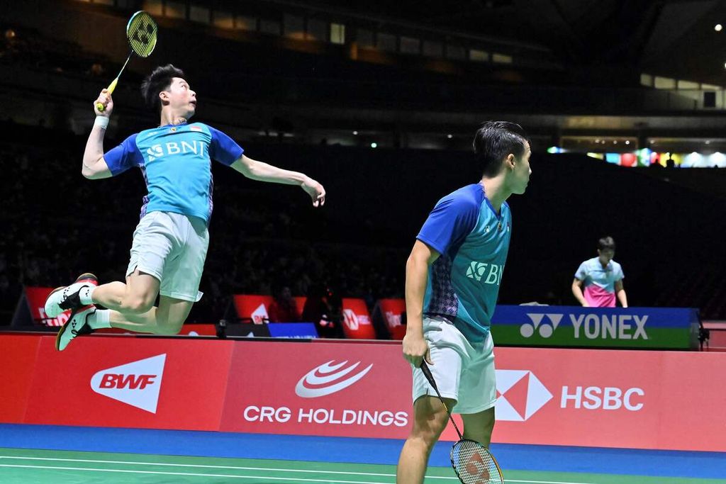 Kevin Sanjaya Sukamuljo melocat untuk memukul kok di belakang pasangannya, Marcus Fernaldi Gideon dalam pertandingan babak kedua Kejuaraan Dunia Bulu Tangkis di Tokyo, Jepang, Rabu (24/8/2022). Kevin/Marcus mengalahkan ganda putra Ceko, Jaromir Janacek/Tomas Svejda 21-14, 21-13. 