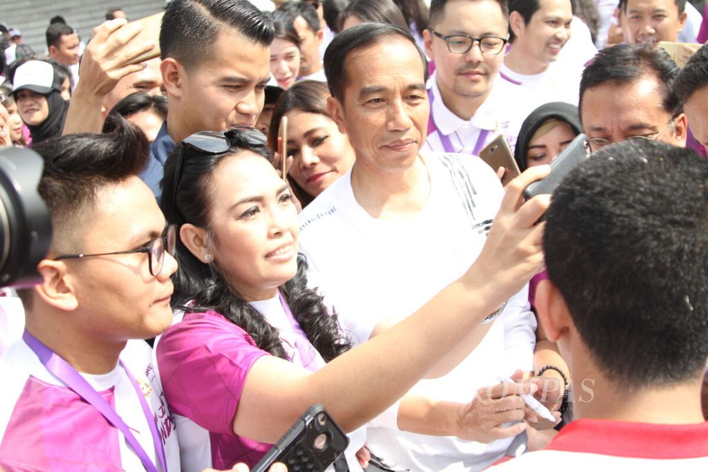 Presiden Joko Widodo melayani swafoto komunitas netizen, atlet, dan selebriti di halaman Istana Kepresidenan Bogor, Jawa Barat, Sabtu (04/08/2018). Dalam kesempatan itu, Presiden meluncurkan program Jalan Terus Indonesia digagas komunitas netizen, atlet, dan selebriti.