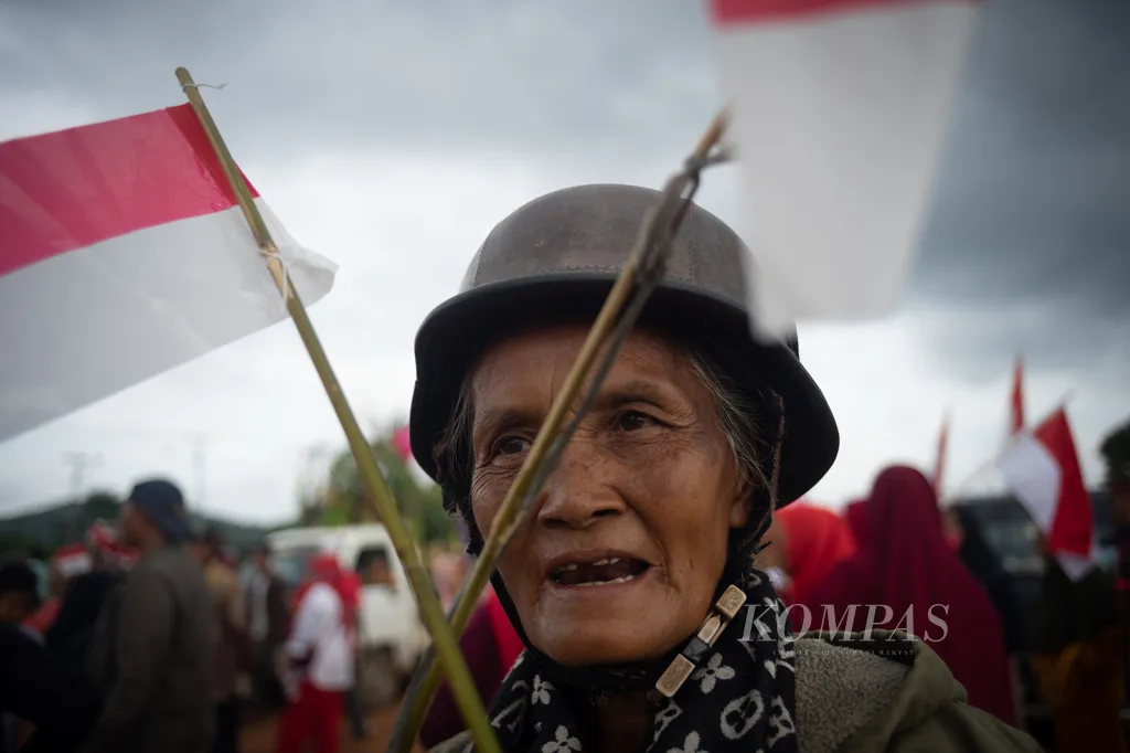 Seorang lansia membawa bendera merah putih saat pawai Kemerdekaan RI di Pulau Rempang, Batam, Kepulauan Riau, Minggu (18/8/2024). Ratusan warga Rempang mengikuti pawai merayakan Kemerdekaan RI sekaligus untuk orasi menolak penggusuran terkait Proyek Strategis Nasional Rempang Eco City.